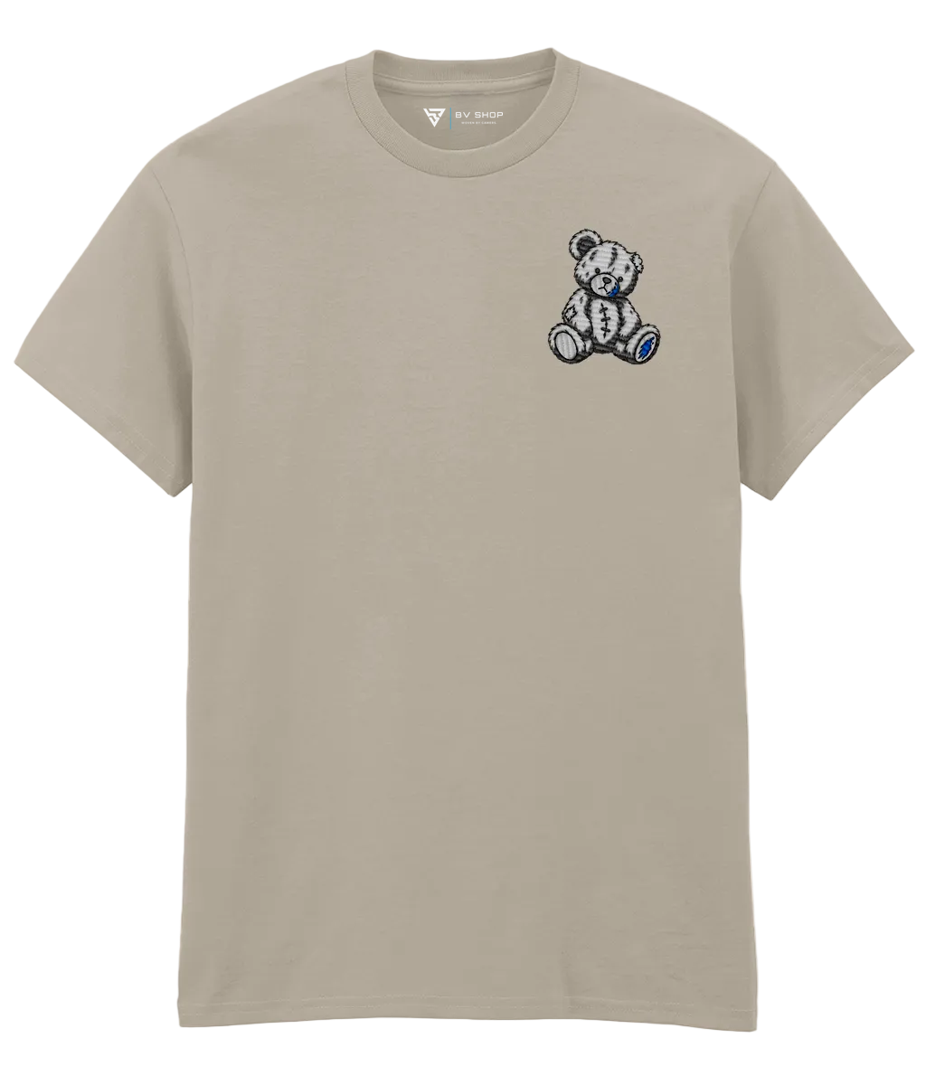 BV Shop UNLUCKY BOX cream T-shirt with stitched teddy bear embroidery, blue accents and NO TUTORIAL collection title.